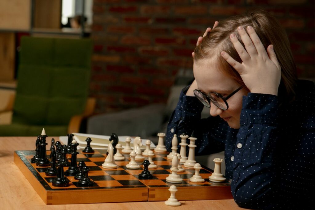 young girl thinking hard in a chess game to show why does chess make you smarter 