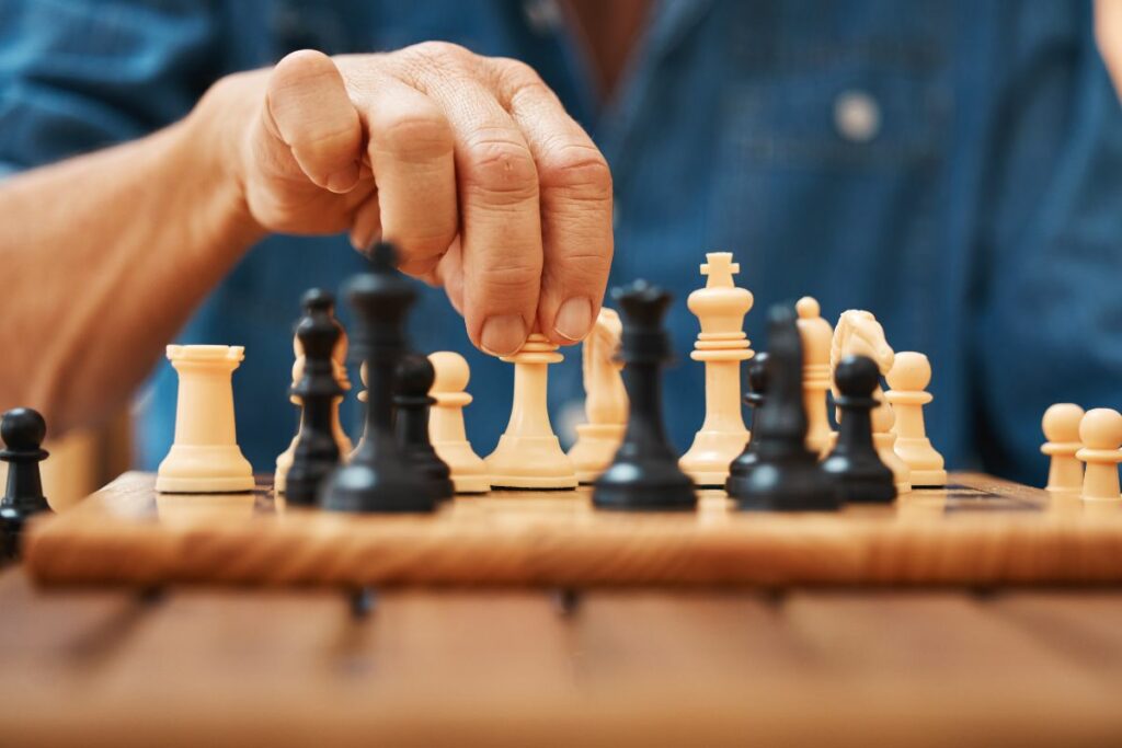 a photo of a chess player touching a piece to show the touch-move rule in chess