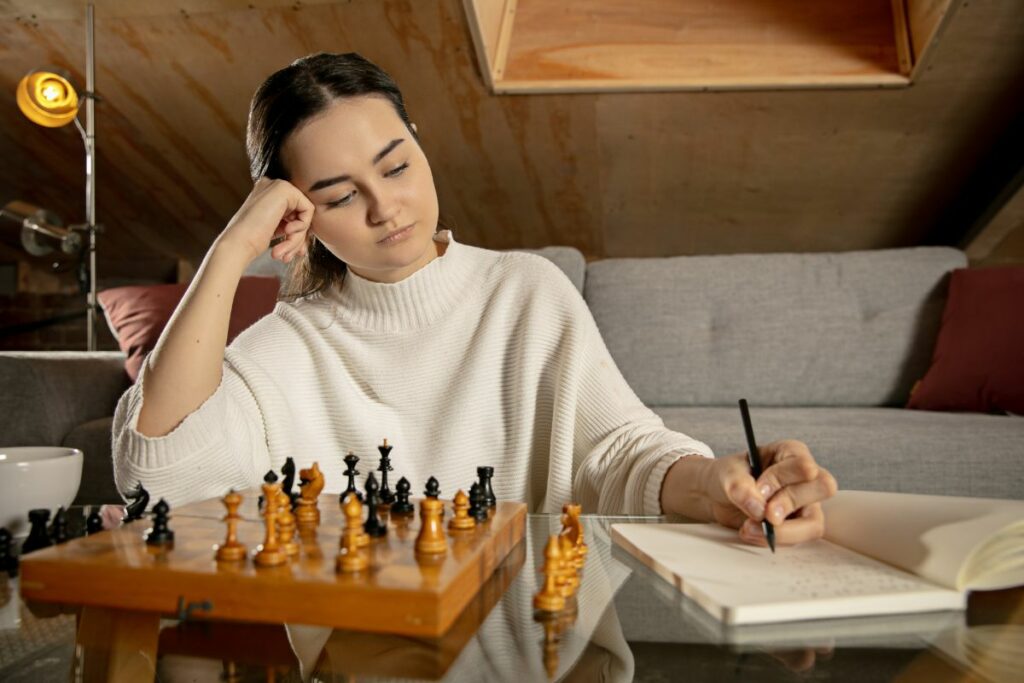 a photo of a chess player with a notebook to show why do chess players write down their moves